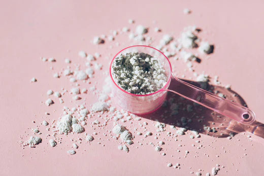 Measuring spoon with magnesium on pink background