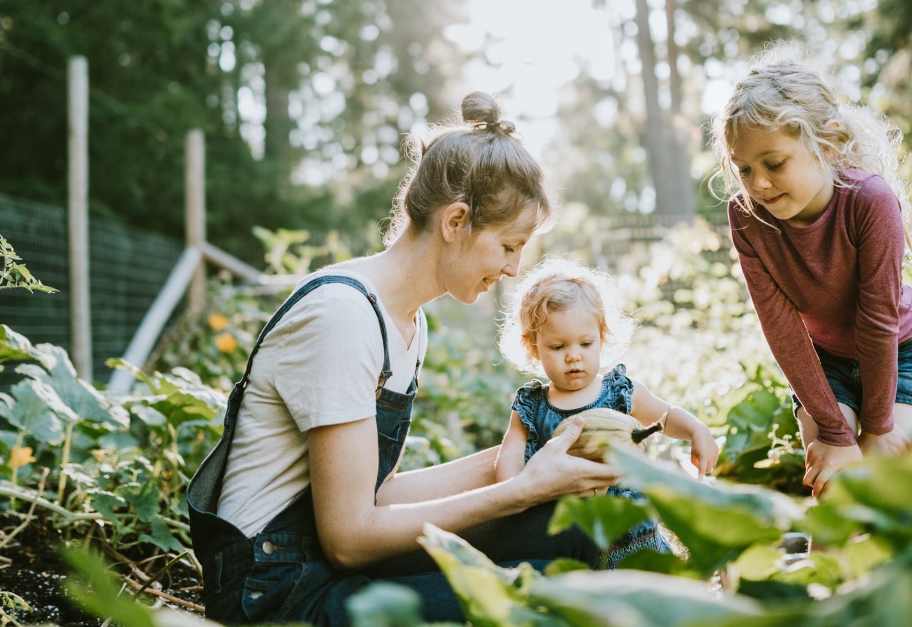 Mother gardening with two children